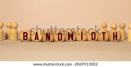 Wooden Blocks with the text: BANDWIDTH. The text is written in black letters and is reflected in the mirror surface of the table. New business relaunch startup concept.