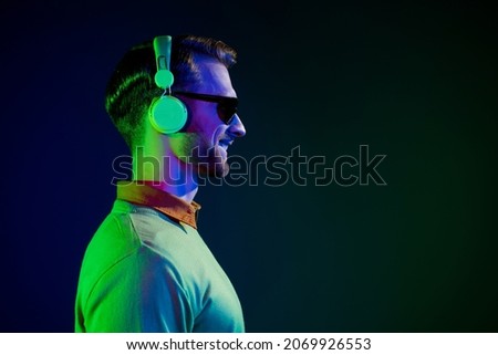Photo portrait of man wearing sunglass headphones smiling looking copyspace isolated dark color background