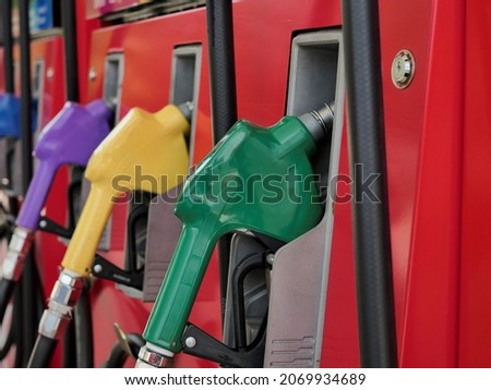 fuel dispenser. The green fuel nozzles are arranged in several colors. Gasoline and diesel service stations. The green fuel dispenser is installed in the red oil dispenser. Royalty-Free Stock Photo #2069934689