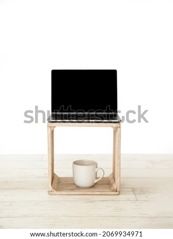 laptop with black screen on wooden crate isolated over white background, on-line work and education, distant learning.