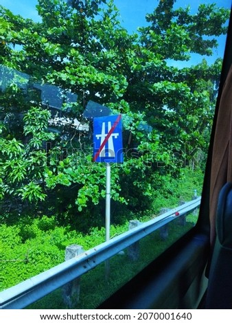 The blue traffic signs on the edge of the toll road are very helpful for driving safety