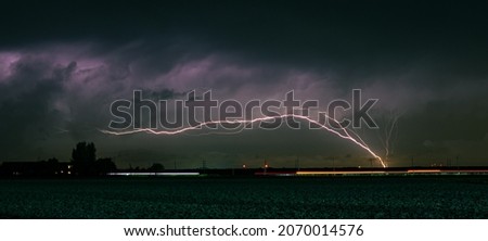 Lightning bolt shoots up from an offshore wind farm over the North Sea. Phenomenon also known as GC (Ground to Cloud) lightning. Royalty-Free Stock Photo #2070014576