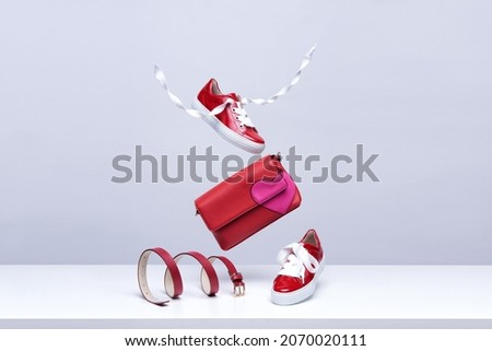 Women's shoes and accessories flying in the air on a light background. Fashionable women's items. Fashionable and modern womens handbag and shoes Royalty-Free Stock Photo #2070020111