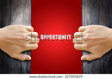 Hand opening a wooden door found the word "OPPORTUNITY".