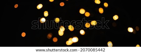 Abstract bokeh, orange glitter sparkle for christmas and new year eve party. Black background, banner photo