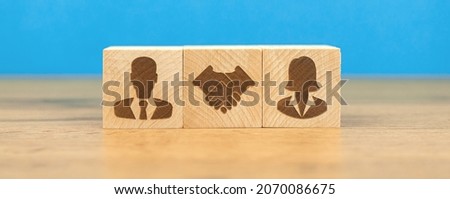 Concept of team. Female and male person hand shaking. Cooperation, collaboration. Wooden cubes with icons photo