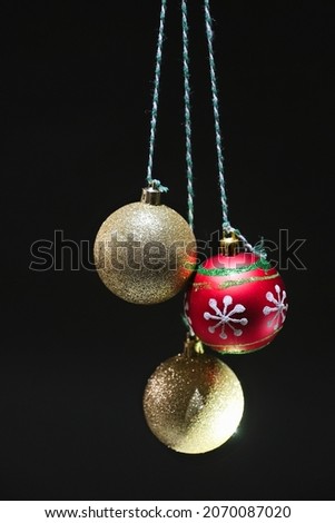 Three beautiful Christmas balls hung over dark backgound
