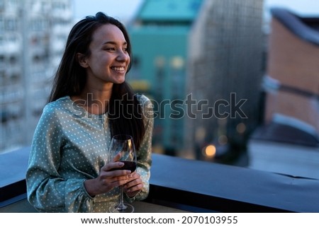 Storytelling image of woman dining on a rooftop. Family and friends make a reunion at home. 