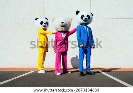 Storytelling image of a couple wearing giant panda head and colored suits. Man and woman making party in a parking lot. Royalty-Free Stock Photo #2070134633