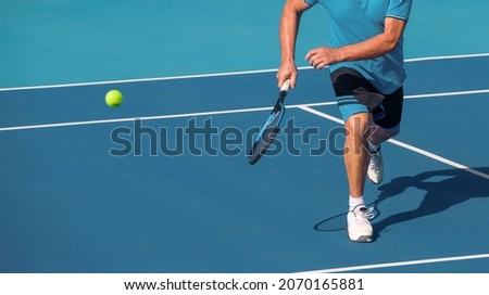 Tennis player playing tennis on a hard court on a bright sunny day Royalty-Free Stock Photo #2070165881