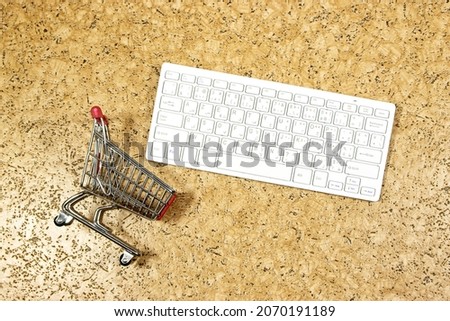 Internet online shopping concept with computer and miniature cart 