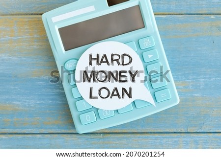 Hard money loan text on small sheet and wooden background. High resolution photo - business concept