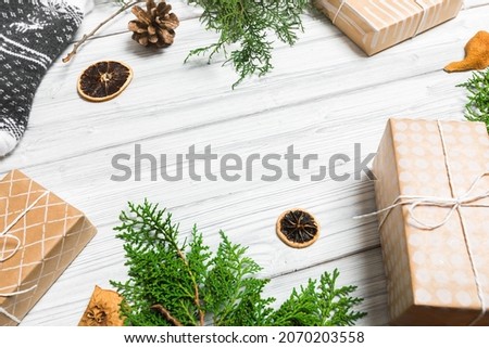 Christmas branches, gift boxes and dried fruits on white wooden table. Christmas background. Flat lay. top view with copy space