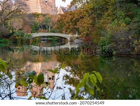 Bow Bridge in Central Park, New York City, with sharp reflection and fall foliage. 