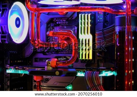 Close-up and inside high performance Desktop PC and water cooling system on CPU socket with multicolored LED RGB neon light show status on working, interior on Computer PC Case and DIY