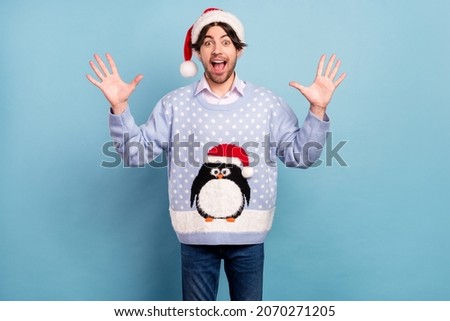 Photo of impressed cute young man dressed blue christmas pullover open mouth rising arms isolated blue color background