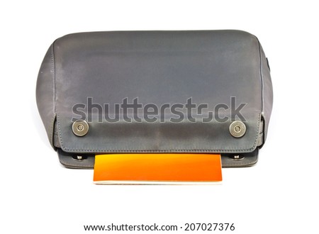 Book in old black leather women bag on white background