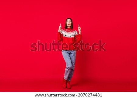 Photo of sweet shocked young lady wear print sweater pointing up empty space isolated red color background