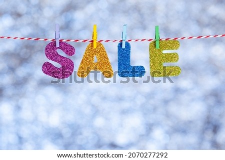 Christmas sale. Shiny letters on a blurred blue-gray background. Copy space. Concept