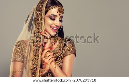 Portrait of beautiful indian girl. Young hindu woman model with golden kundan jewelry set . Traditional Indian costume lehenga choli . Royalty-Free Stock Photo #2070293918