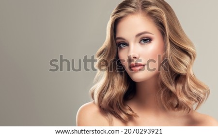 Beautiful model girl with short hair .Beauty woman with blonde curly hairstyle dye .Fashion, cosmetics and makeup Royalty-Free Stock Photo #2070293921