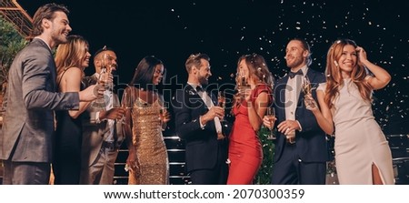 Group of beautiful people in formalwear communicating and smiling while spending time on luxury party Royalty-Free Stock Photo #2070300359