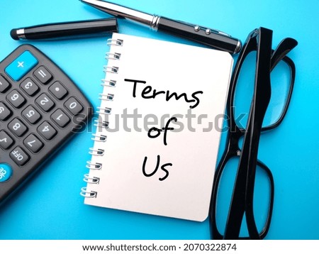 Calculator,pen,glasses and notebook written with text Terms of us.Business concept.