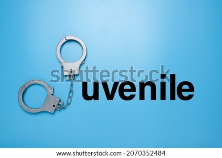 A picture of handcuff with "juvenile" word on blue background.