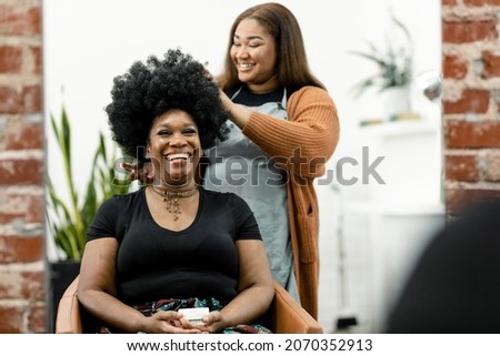 Hairstylist giving a haircut to a customer at a beauty salon Royalty-Free Stock Photo #2070352913