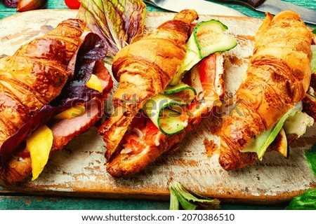 Fresh croissants with salted filling.Croissants with trout, meat bacon, vegetables and fruits Royalty-Free Stock Photo #2070386510