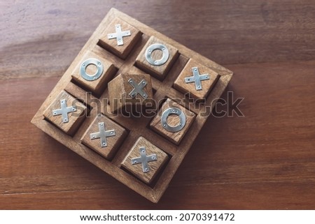 Vintage Tic Tac Toe wooden board game on wooden top table with selective focusing, planing and thinking conceptual
