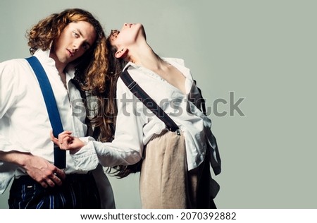 Young couple in love hug each other. Fashion couple on black background in studio. Fashionable people.