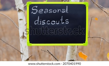 frame with text. seasonal, autumn discounts. Chalkboard and autumn leaves. natural background. the sign weighs on the tree. close-up. sale, big discounts, percent. empty space for text