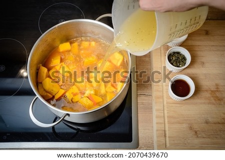 Pumpkin soup recipe - the chef's hand puts the ingredients in the pot and cooks everything to go with the soup