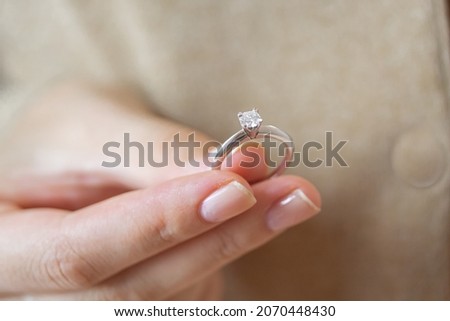 Caucasian woman holding simple solitaire diamond engagement ring white gold  Royalty-Free Stock Photo #2070448430