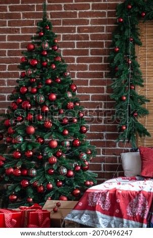 Large Christmas tree with red Christmas balls in the interior of the room.