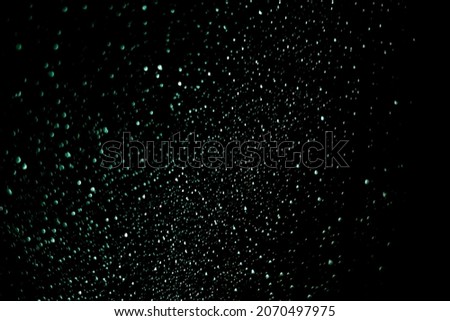 Defocused Lights and Bokeh. Abstract Background. Stock photo. Glitter Background. Magical and Christmas Effect. Colored raindrops over dark background.