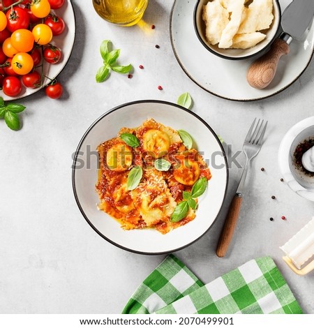 Homemade italian ravioli pasta, stuffed with spinach and ricotta ,served with tomato sauce, parmesan cheese and fresh basil leaves . Top view	 Royalty-Free Stock Photo #2070499901