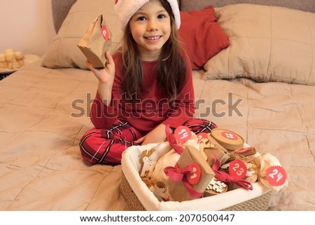 portrait of happy curious girl opening the Gift Of DIY Advent Calendar