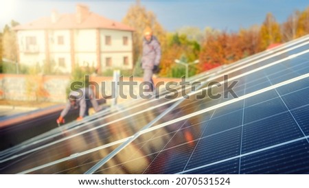 Solar panels on the roof of the building in the sun with workers. For alternative energy design. Selective focus. Blur Royalty-Free Stock Photo #2070531524
