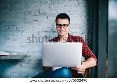 Happy hipster guy connecting to 4g internet on modern laptop computer for watching funny video, cheerful male programmer working remotely with graphic web design using modern netbook technology
