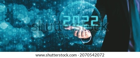 Businessman hand holding 2022 number,happy new year concept digital trends,industry and business trend of world full modernity advanced technology,artificial intelligence or AI,banner header panoramic