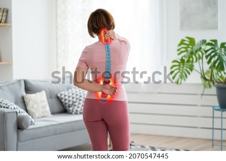 Intervertebral hernia, neck and lumbar pain, woman suffering from backache at home, spinal disc disease, health problems concept Royalty-Free Stock Photo #2070547445