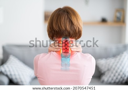 Intervertebral hernia of the cervical spine, neck pain, woman suffering from backache at home, spinal disc disease, health problems concept Royalty-Free Stock Photo #2070547451