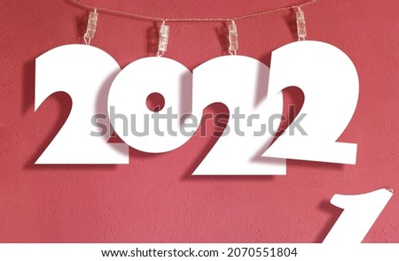 Mockup papercut 2022 sign hanging on a laundry string. New year replacing the old one concept.  Royalty-Free Stock Photo #2070551804
