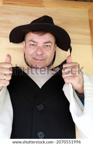 Man posing face in hole board of Finnish folk