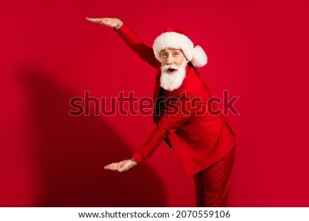 Photo of impressed white hair aged man hands measure wear santa cap red suit isolated on red color background
