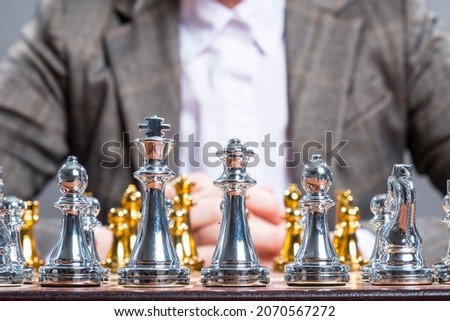 The woman plays chess. Chess board and pieces on the table.