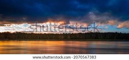 Dramatic sunrise cloudscape over the Cape Cod Canal Riverbank. Long exposure photography.