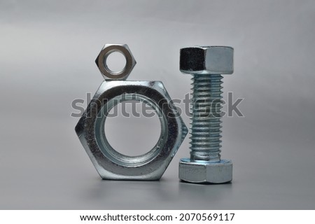 composition of new bolts and nuts of different sizes on a gray background